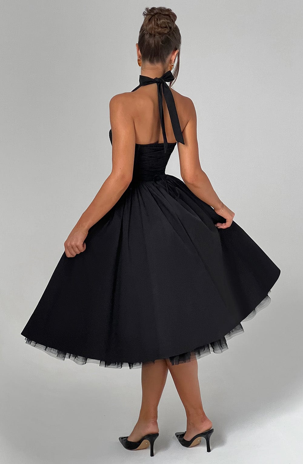 Sophisticated black women's dress, halter neck and midi length, for formal occasions.
