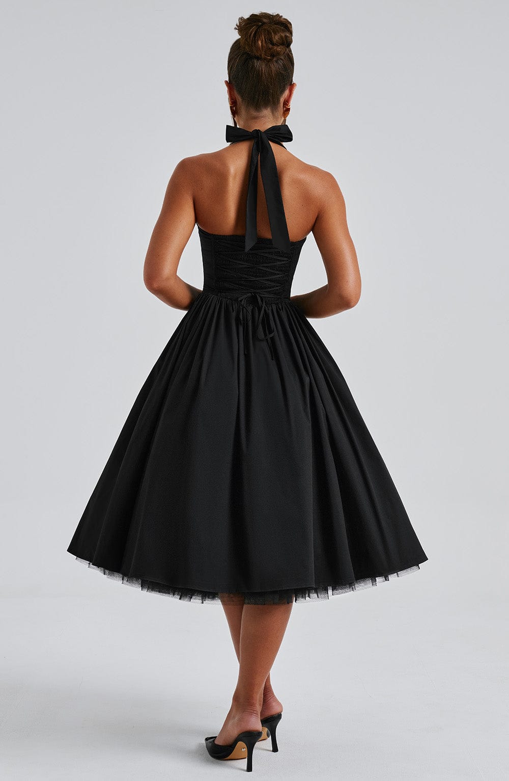 Sleek black cocktail dress, halter neck design, a refined choice for evening wear.