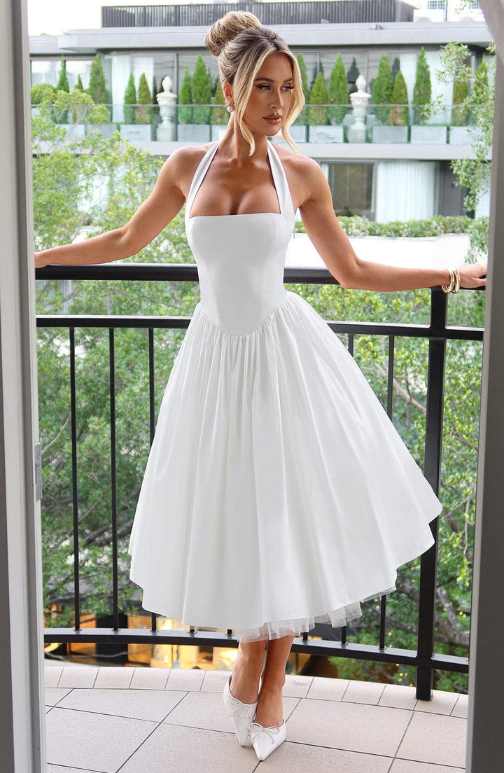 Women's formal black halter neck cocktail dress with cinched waist, full length.