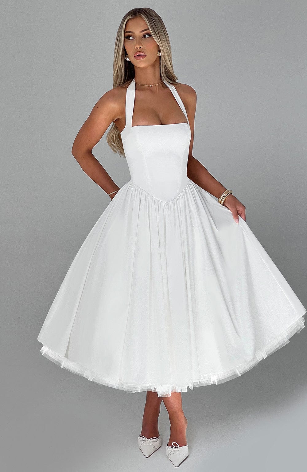 Black halter neck wedding guest dress, showing back detail and modest length.