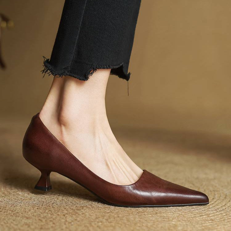 Classic women's refined pointed toe leather pumps with a comfortable low heel, ideal for dress occasions.