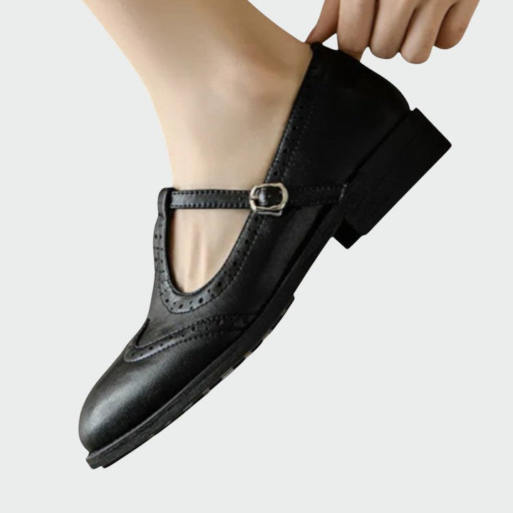 Close-up of T-bar strap and brogue detailing on a stylish women's leather Mary Jane shoe