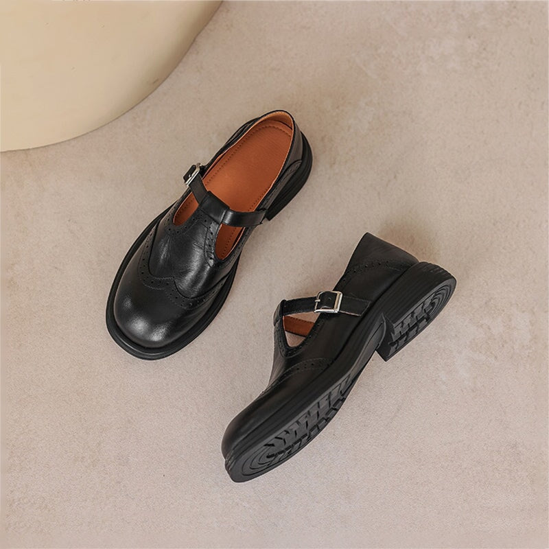 Black leather T-strap Mary Janes for women, featuring elegant brogue detailing and comfort