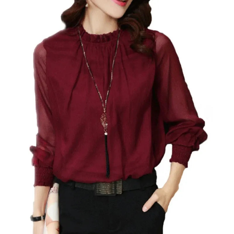 Close-up of elegant women's long sleeve black ruffle blouse, showing fabric detail.