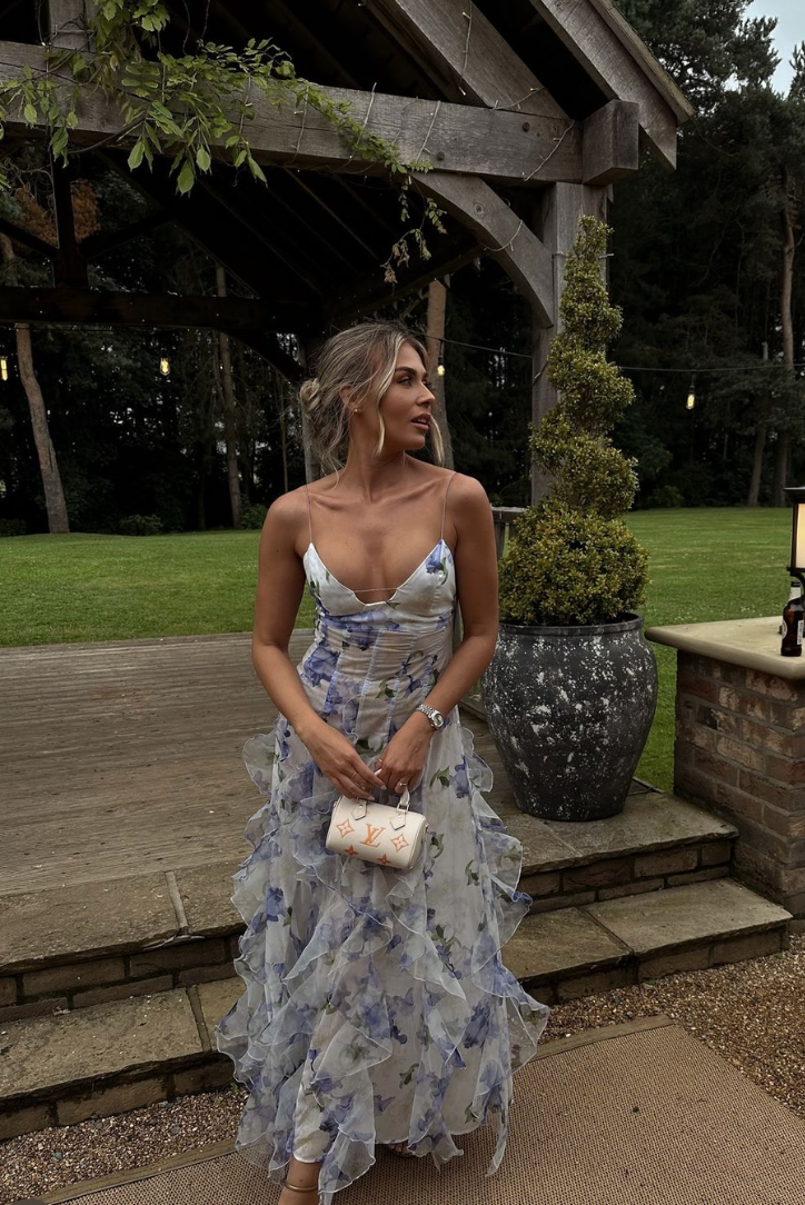 Women모델 wearing a blue floral cut-out maxi dress, showcasing its elegant and vacation-ready style.