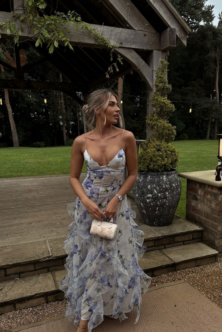 Women모델 wearing a blue floral cut-out maxi dress, showcasing its elegant and vacation-ready style.