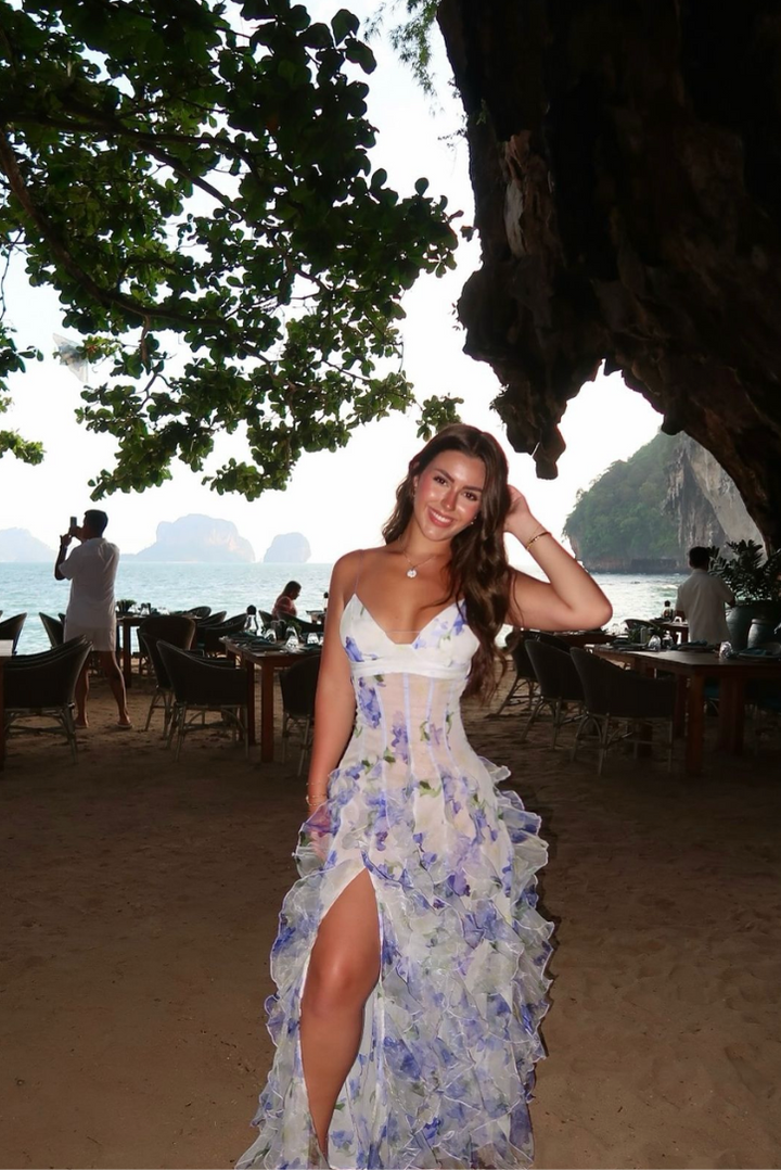 Back view of a women's elegant blue floral maxi dress with cut-out, suitable for summer fashion.