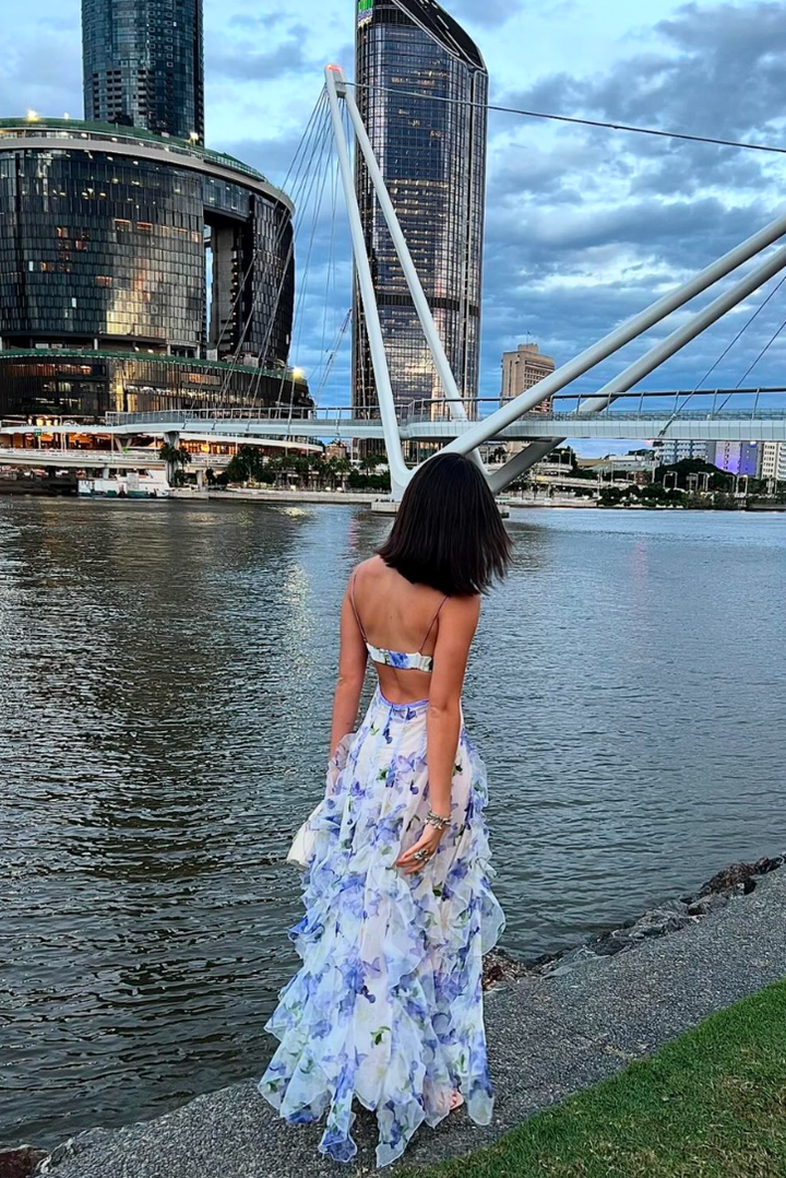 Vibrant blue floral print on a women's elegant maxi dress with trendy cut-outs, perfect for vacation.