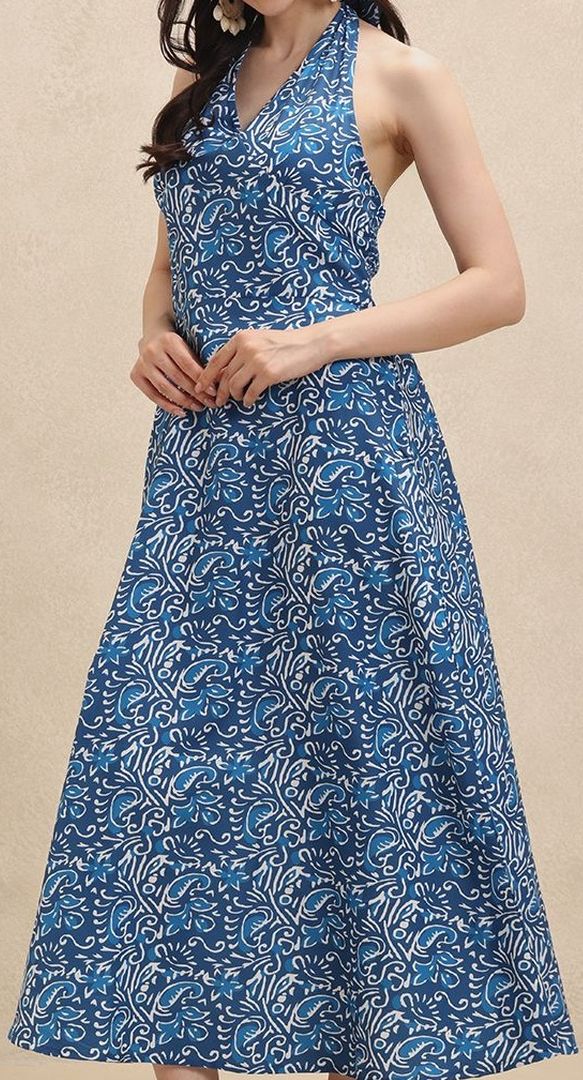 Close-up of blue & white floral pattern on an elegant women's halterneck maxi dress for summer holiday.