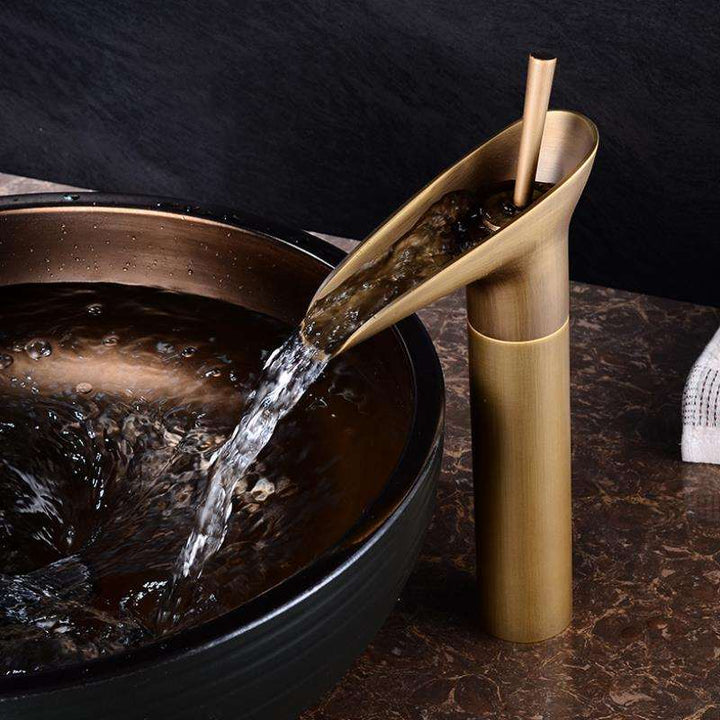 Elegant brass waterfall bathroom faucet for basin. Stylish mixer tap enhances home decor.