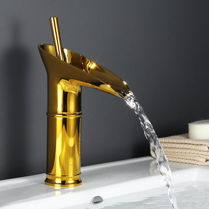 Brass waterfall mixer tap with elegant design. Gold bathroom faucet for stylish sink.