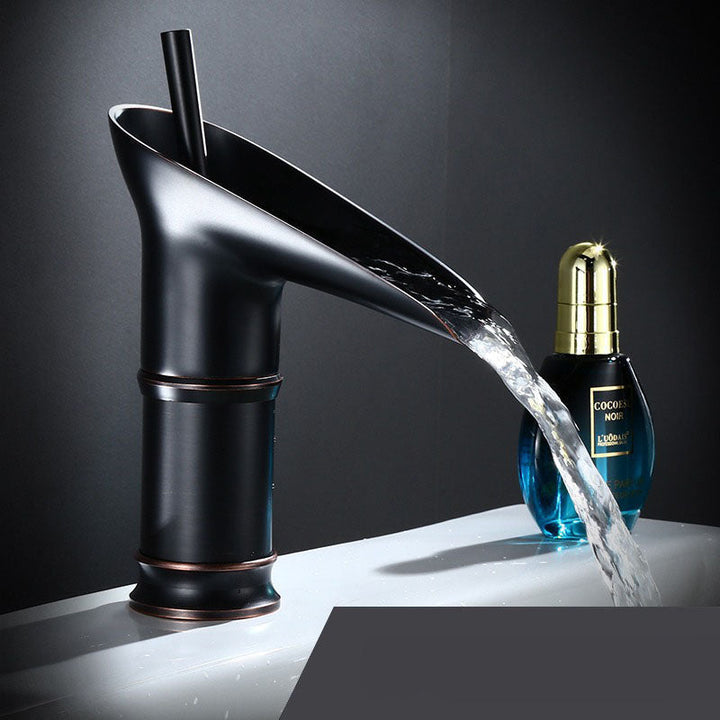 Unique waterfall sink tap in elegant brass. Modern bathroom mixer faucet design.