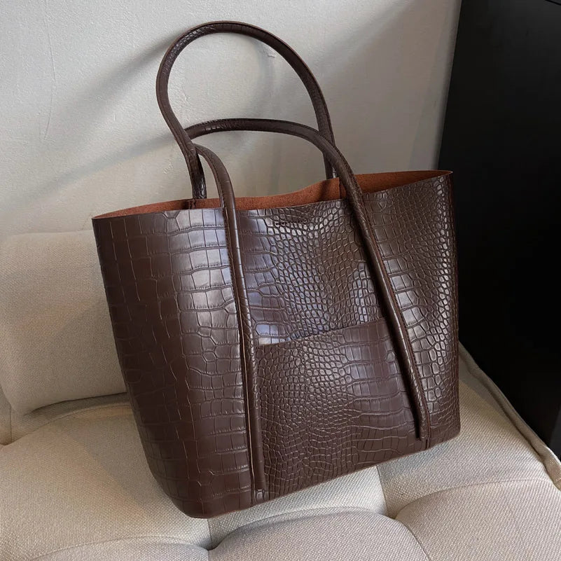 Close-up of croc embossed texture on a women's shoulder bag, vintage leather handbag detail