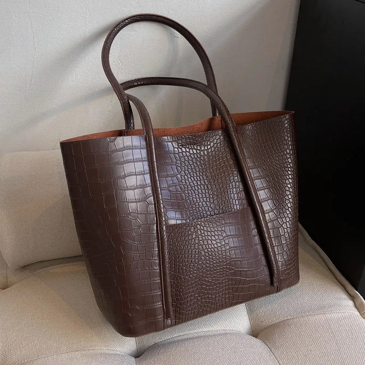 Close-up of croc embossed texture on a women's shoulder bag, vintage leather handbag detail