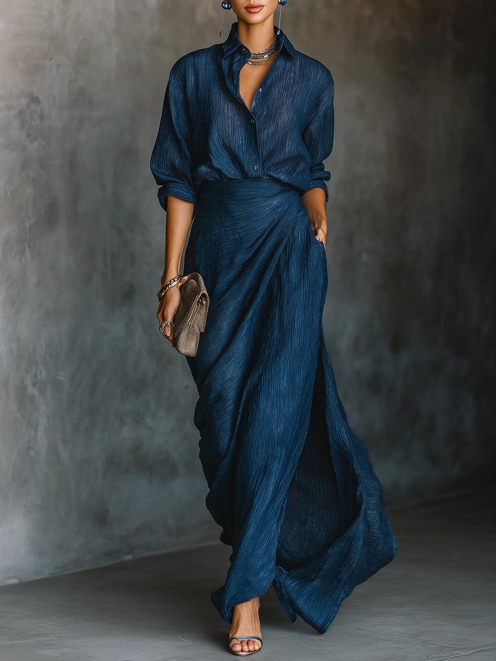 Elegant dark blue women's two-piece set, featuring a tailored long-sleeve shirt and matching flowing long skirt, ideal for formal wear.