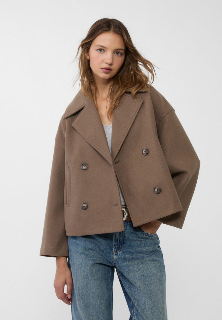 Woman showcasing elegant lightweight double-breasted summer jacket. Stylish & comfortable outerwear.
