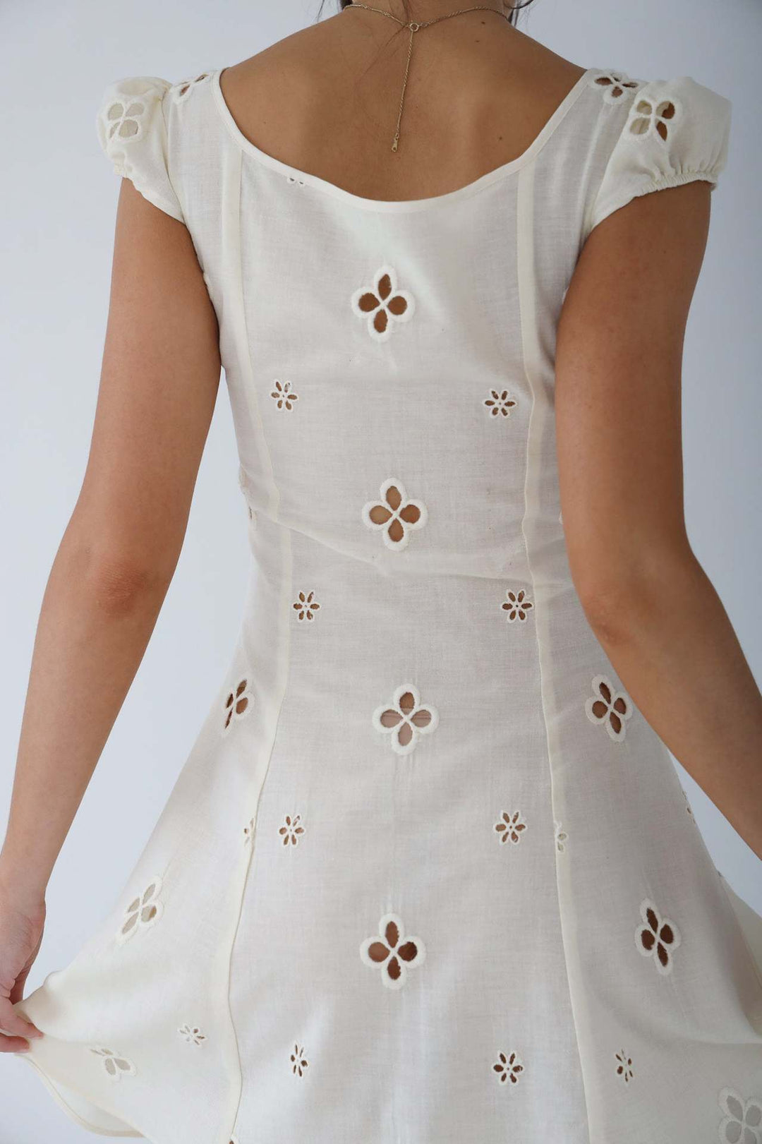 Rear view of a women's white mermaid formal dress, showcasing its elegant train and flattering silhouette.