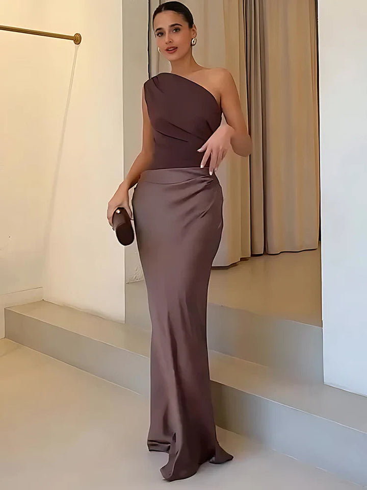 Classic black one-shoulder satin maxi dress paired with minimalist accessories, formal wear.