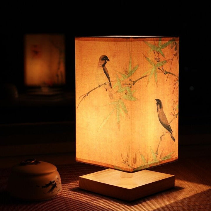 Scandinavian-style accent lamp with an artistic Japanese print fabric shade, adds warmth to bedroom decor.