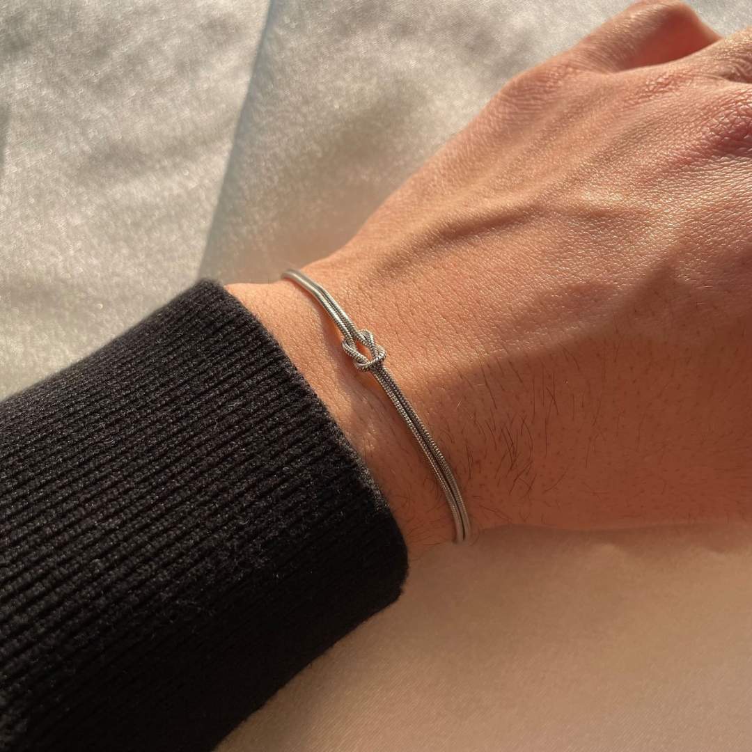 Delicate stainless steel knot bracelet for women, a subtle, elegant, and timeless fashion accessory.
