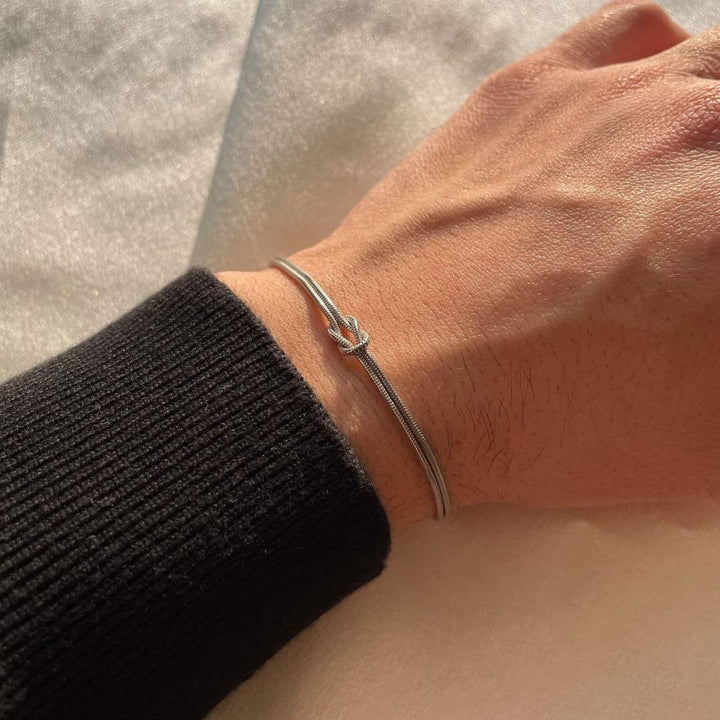 Delicate stainless steel knot bracelet for women, a subtle, elegant, and timeless fashion accessory.