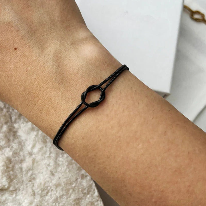 Sleek black stainless steel knot bracelet, an elegant and refined minimalist women's jewelry piece.