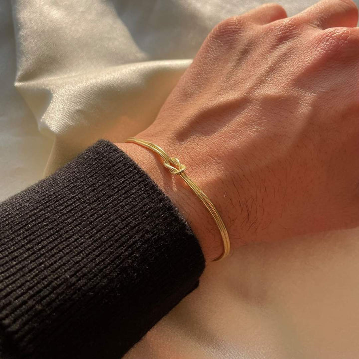 Close-up of a minimalist stainless steel knot bracelet, highlighting its elegant and subtle design.