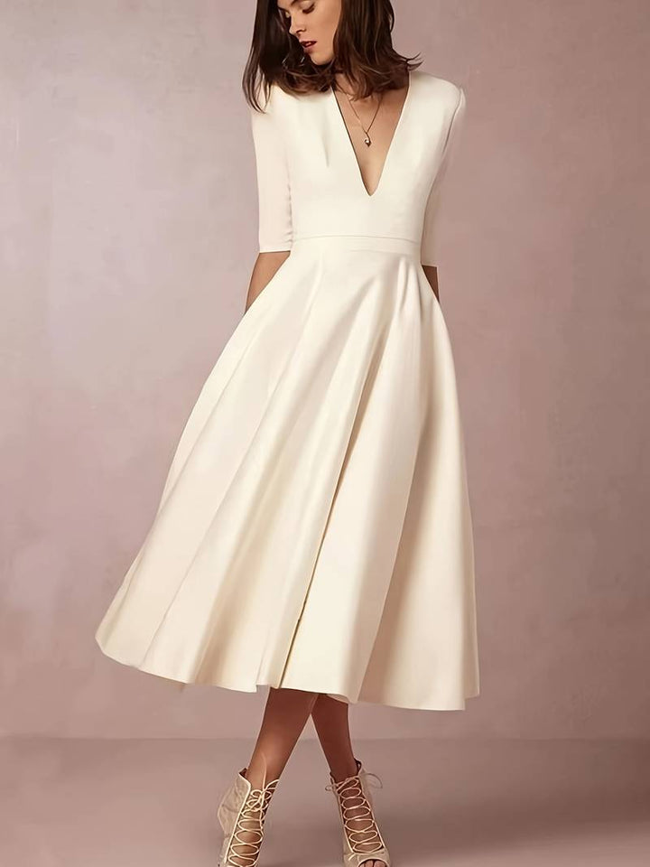 Women's formal white midi dress with flared skirt, perfect elegant wedding guest attire.