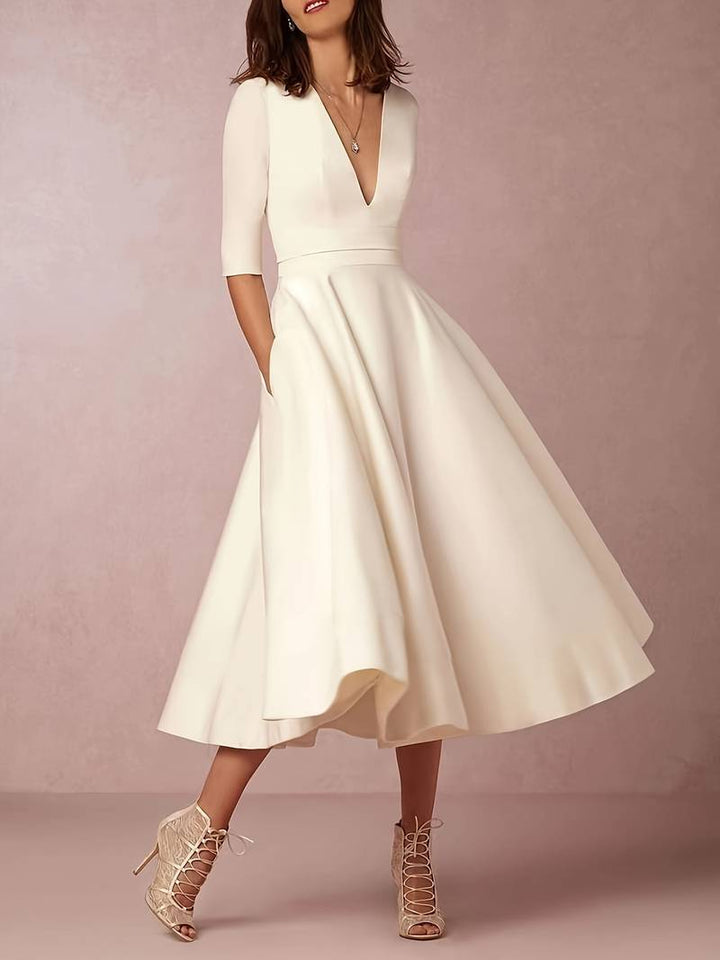 Stylish women's flared midi dress in white, showcasing elegant summer fashion for wedding guests.