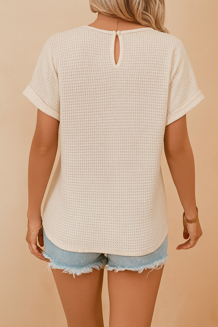 Stylish white summer blouse for women with delicate openwork, a decorative neckline, and comfortable short sleeves.