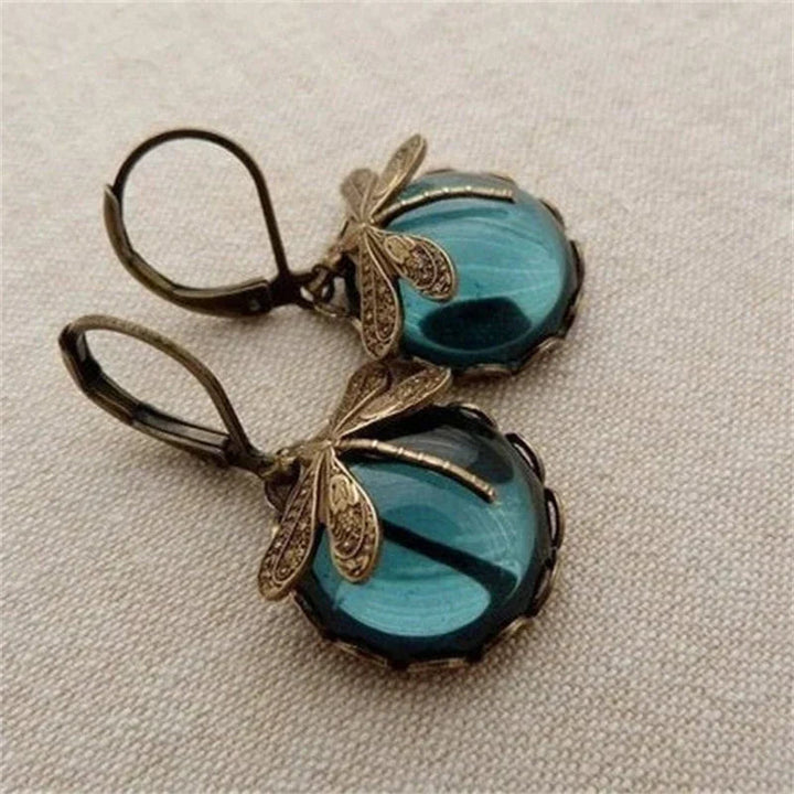 Close-up of sparkling crystal dragonfly earrings with an antique finish, exquisite women's jewelry.