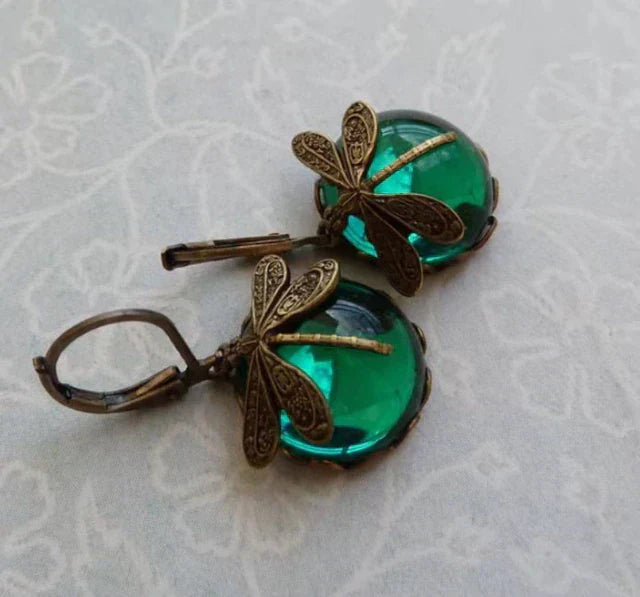 Detailed antique metal and crystal dragonfly earrings, capturing the intricate beauty of nature's design.