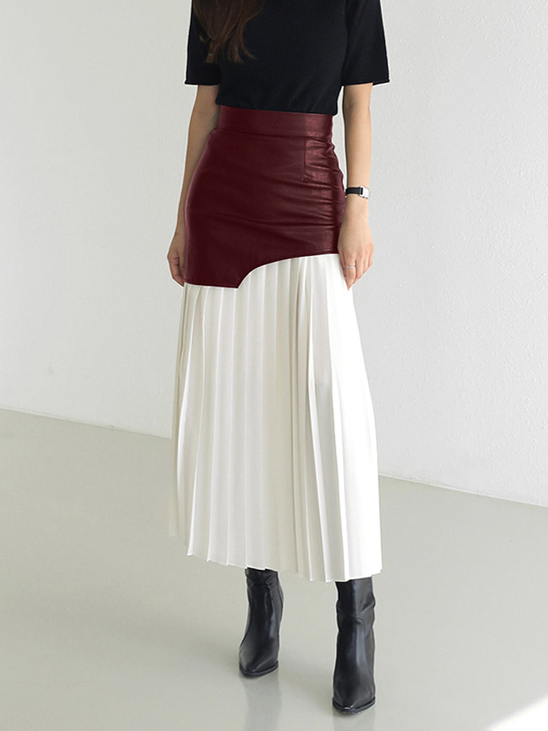 Women posing gracefully in an elegant asymmetrical pleated midi skirt, showcasing its flattering fit.
