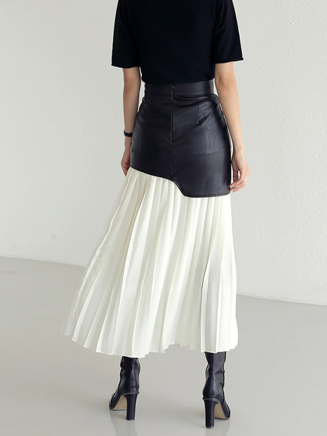 Stylish women's midi skirt with a unique asymmetrical hem and delicate pleats, ideal for spring.