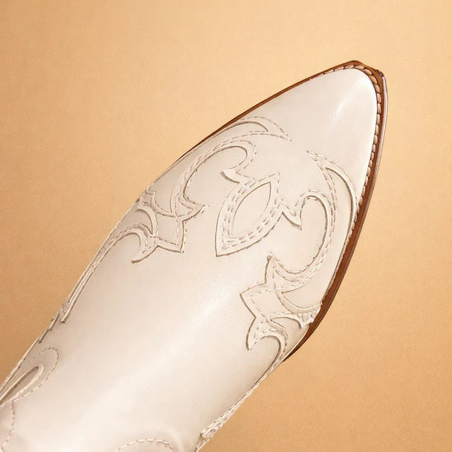 Stylish women's knee-high western boots in beige, featuring detailed embroidered patterns for an elegant look.