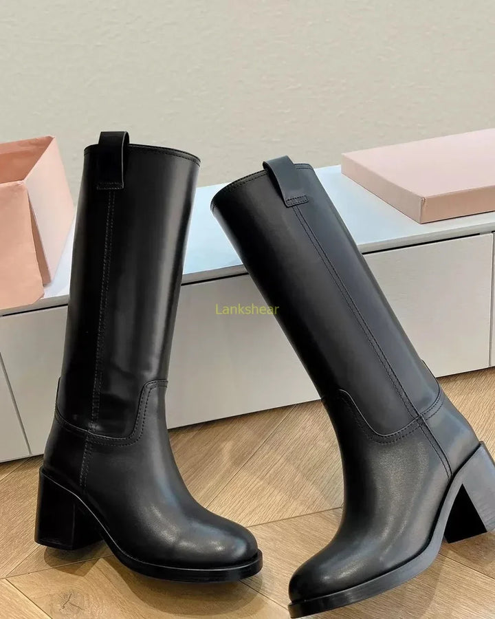 Elegant women's black leather knee-high high heel boots with a sturdy block heel, perfect for fall fashion.