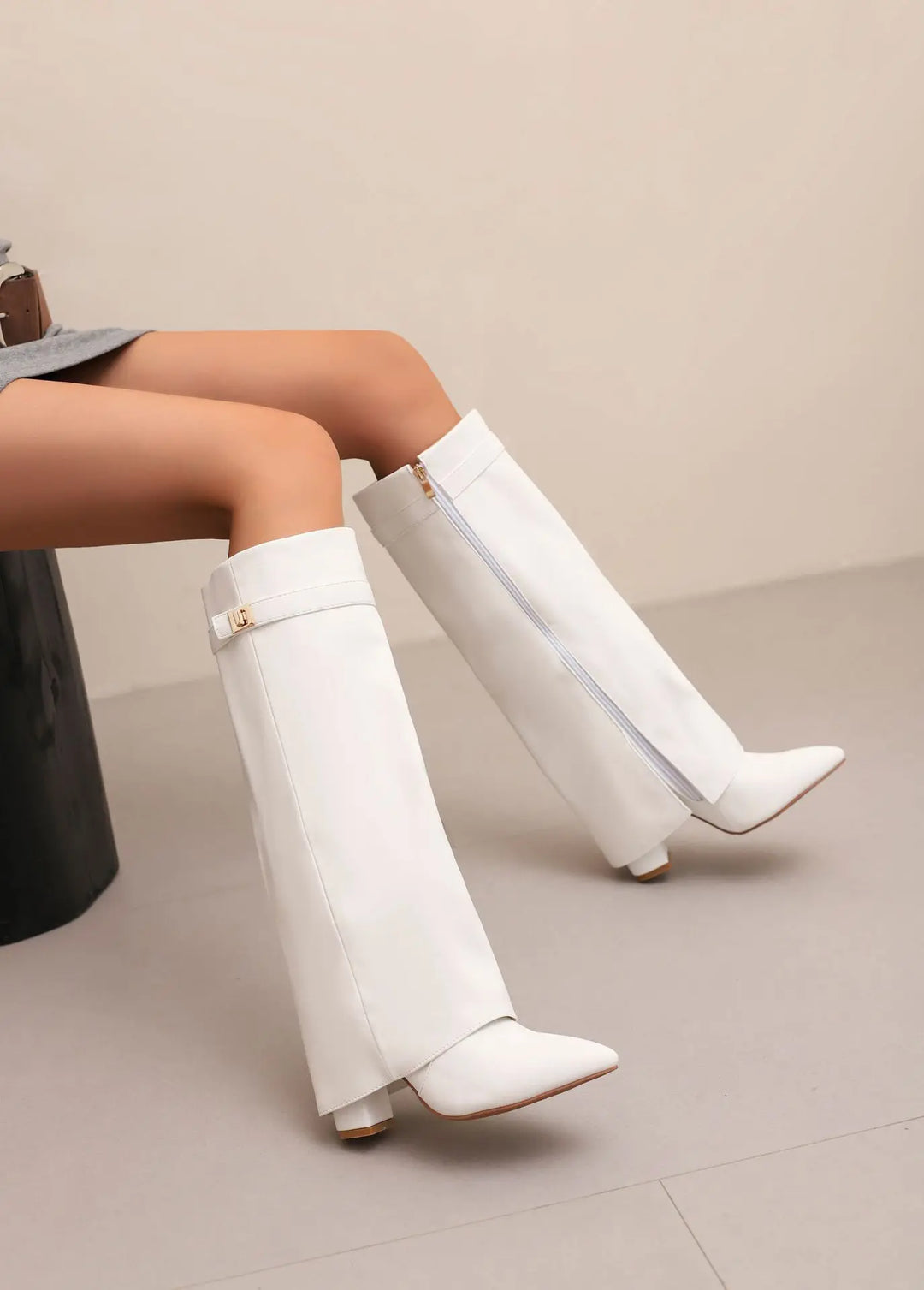 Close-up of the elegant buckled strap on women's black leather thigh-high boots, a key feature.