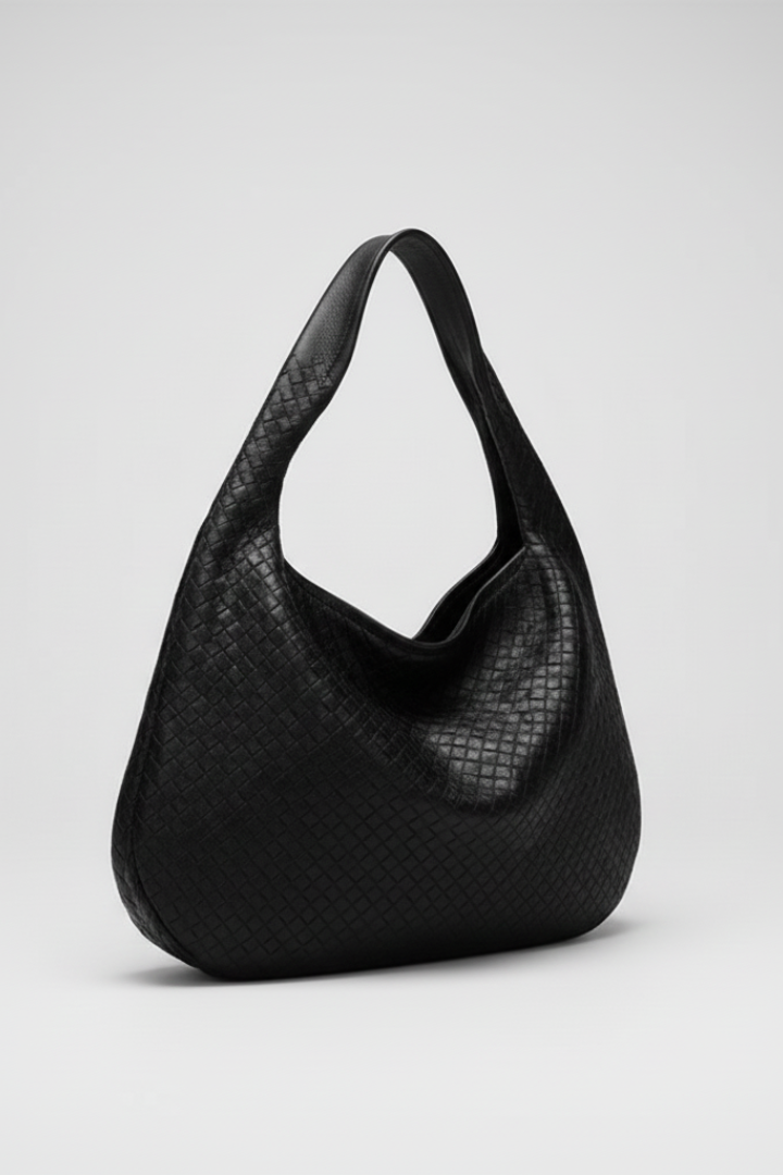 Minimalist black women's shoulder bag with a sleek rounded design and single strap for versatility.