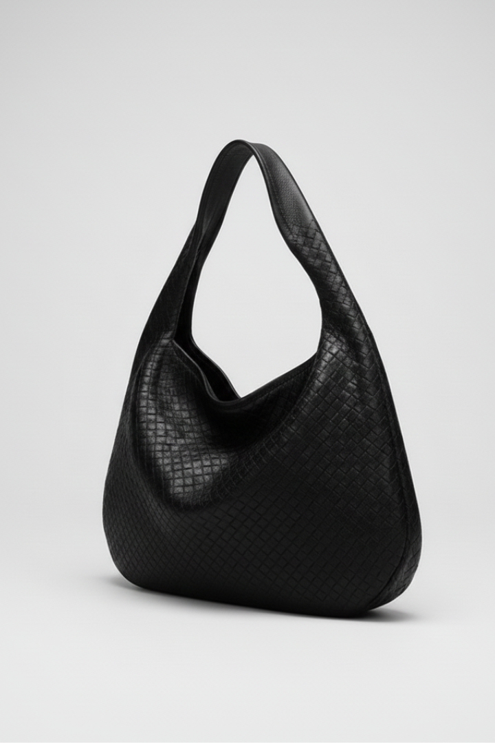 Stylish women's black rounded bag with a single shoulder strap, showcasing an elegant and versatile design.