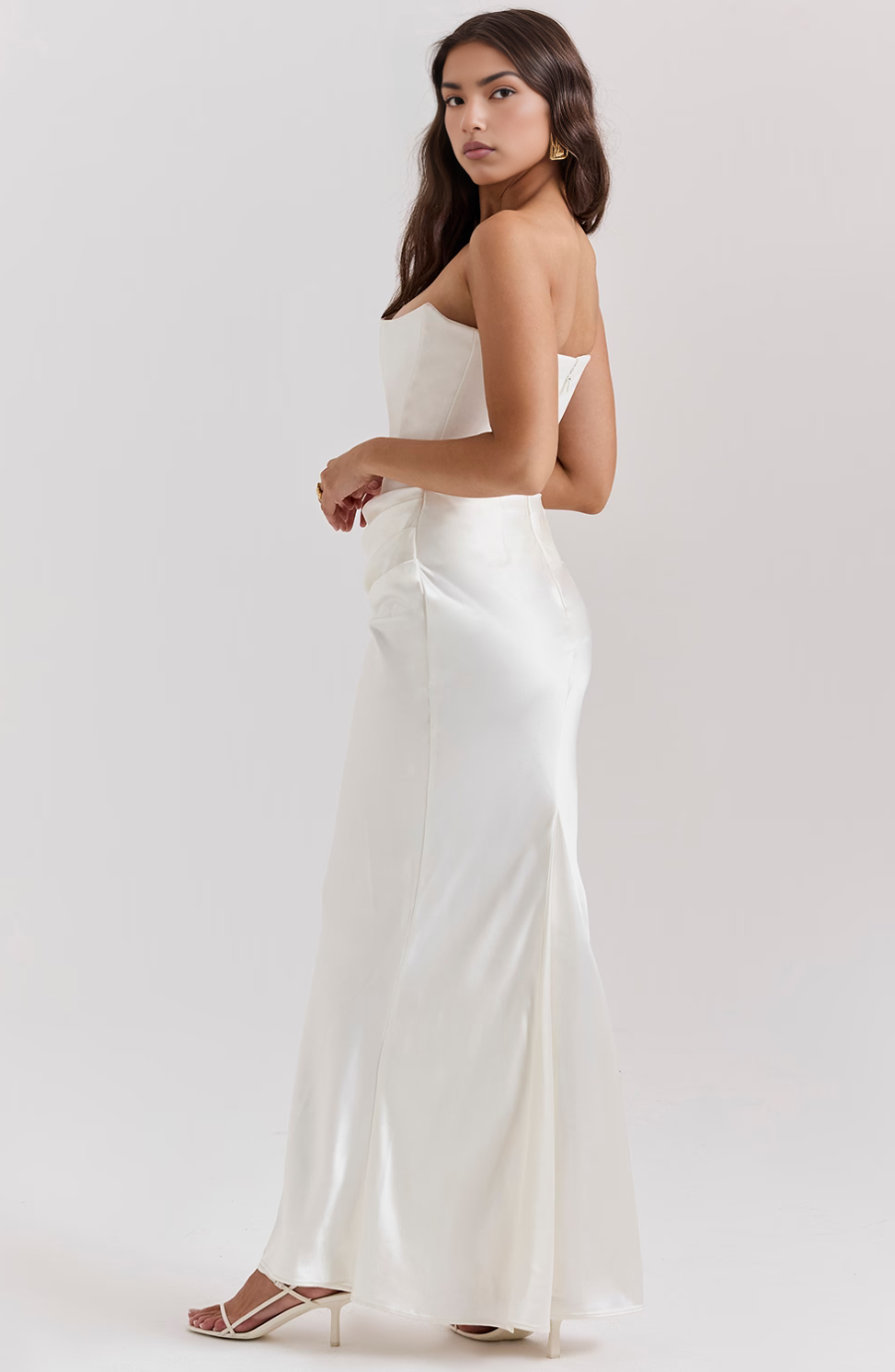 Side profile of a brown strapless corset bodycon maxi dress, highlighting women's evening attire.