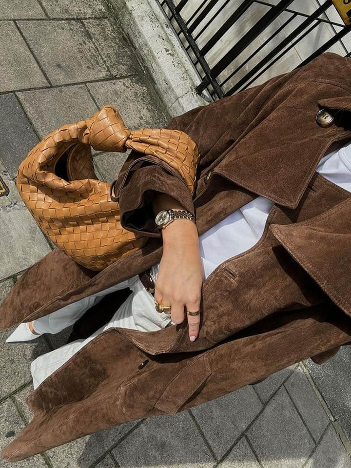 Back view of a women's long brown elegant belted trench coat, showcasing the stylish cut