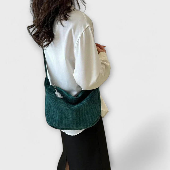 Stylish women's curved shoulder bag in a neutral tone, perfect elegant bag for summer outfits.