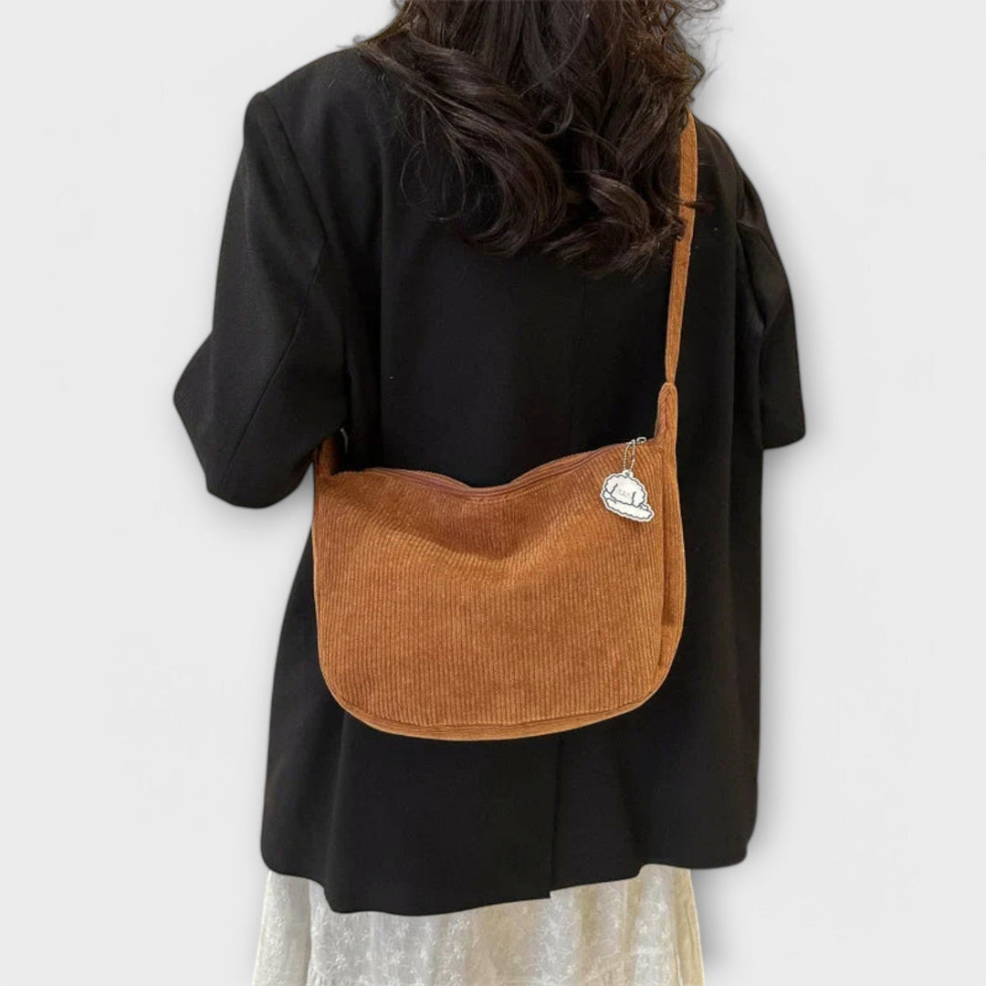Modern women's curved shoulder bag on a model, showcasing its elegant design and comfortable fit.