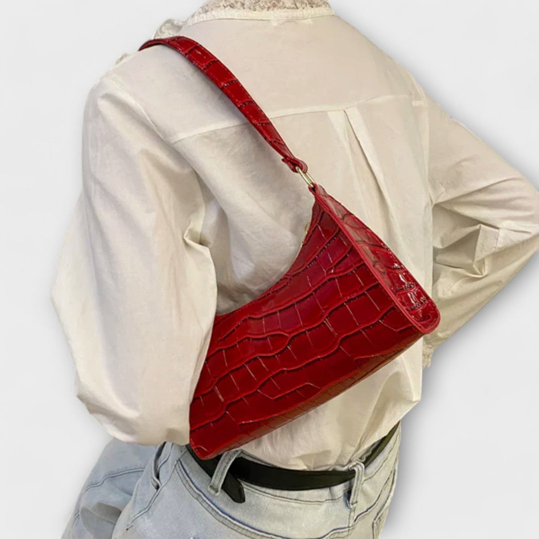 Fashionable ladies' classic textured shoulder bag with a secure flap closure.