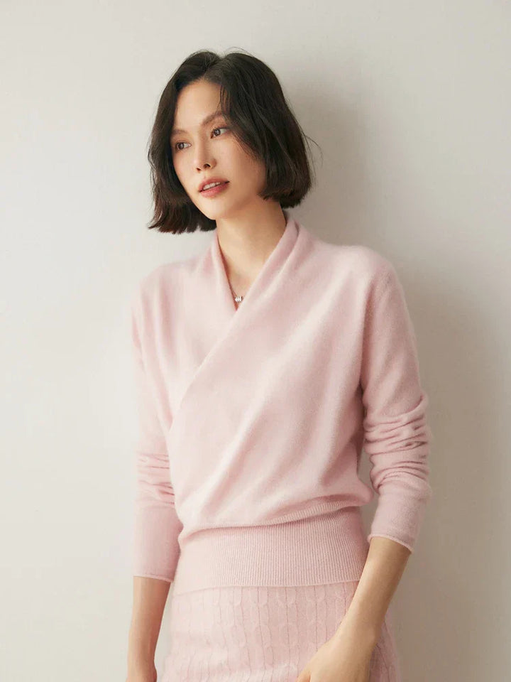 Women's elegant crossover wrap sweater paired with a minimalist skirt for an office look.