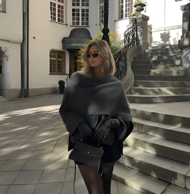 Elegant women's draped cape coat, layered over a sweater, demonstrating its versatility as warm outerwear.