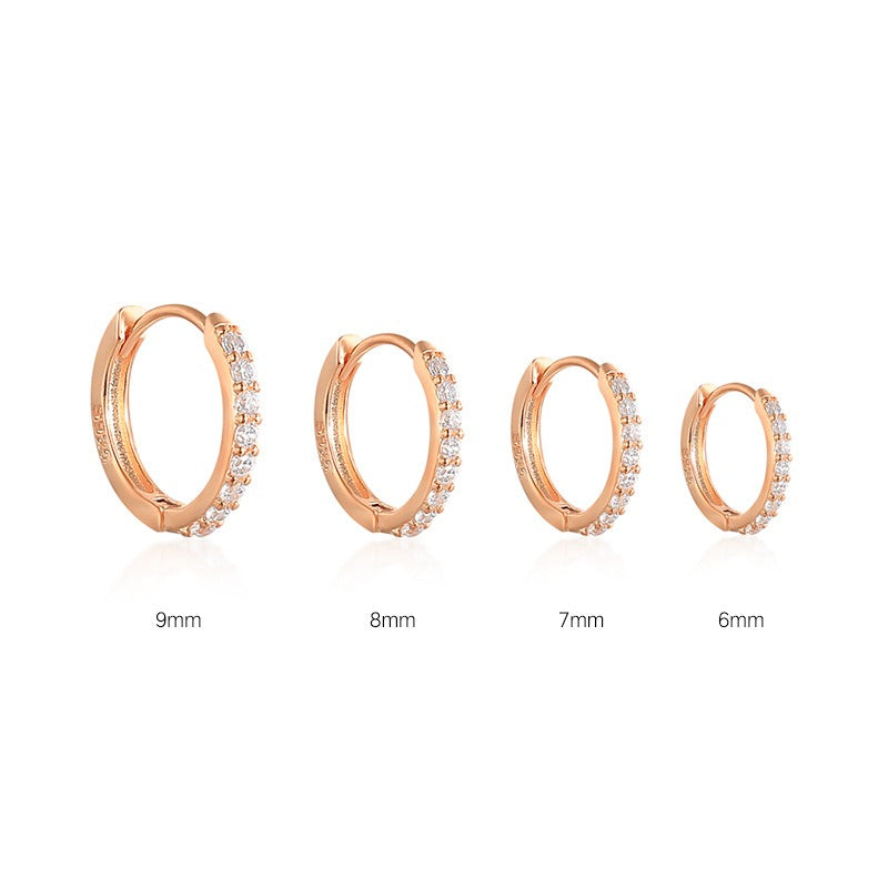 Shiny women's gold earrings featuring sparkling stones, an elegant accessory for her.