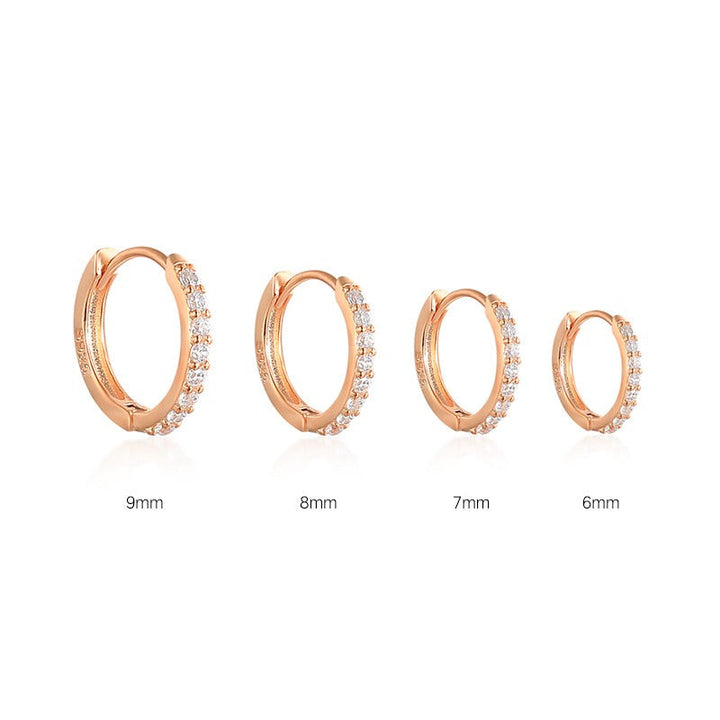 Shiny women's gold earrings featuring sparkling stones, an elegant accessory for her.