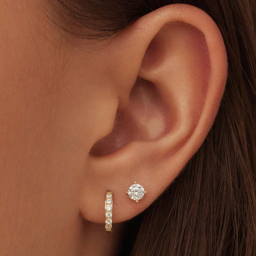 Women's elegant gold earrings with sparkling stones, showcasing a chic accessory.