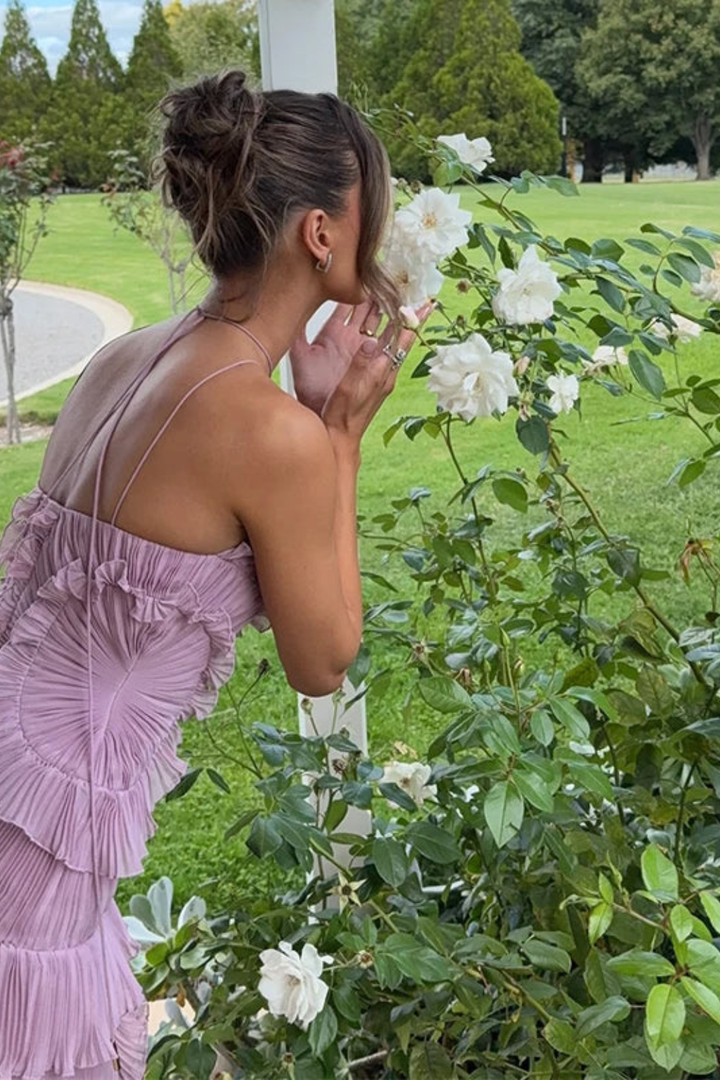 Luxurious women's halter backless pleated ruffled maxi dress, an elegant summer party or wedding guest outfit.